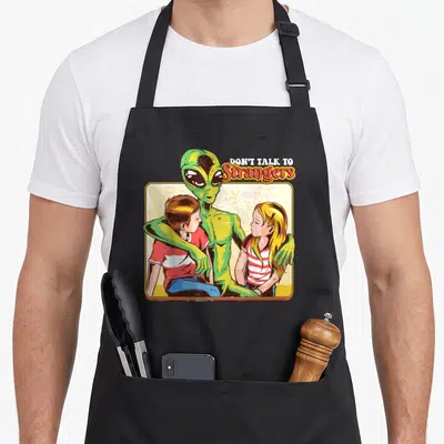 Tablier de cuisine noir avec illustration d'un alien vert entourant deux enfants et le texte Don't Talk To Strangers en style rétro.