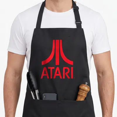 Tablier de cuisine noir avec le logo Atari Games Red Retro imprimé en rouge vif au centre du torse.