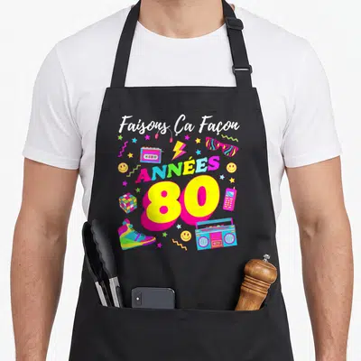 Tablier de cuisine noir avec inscription Faisons Ça Façon Années 80 et illustrations rétro colorées.