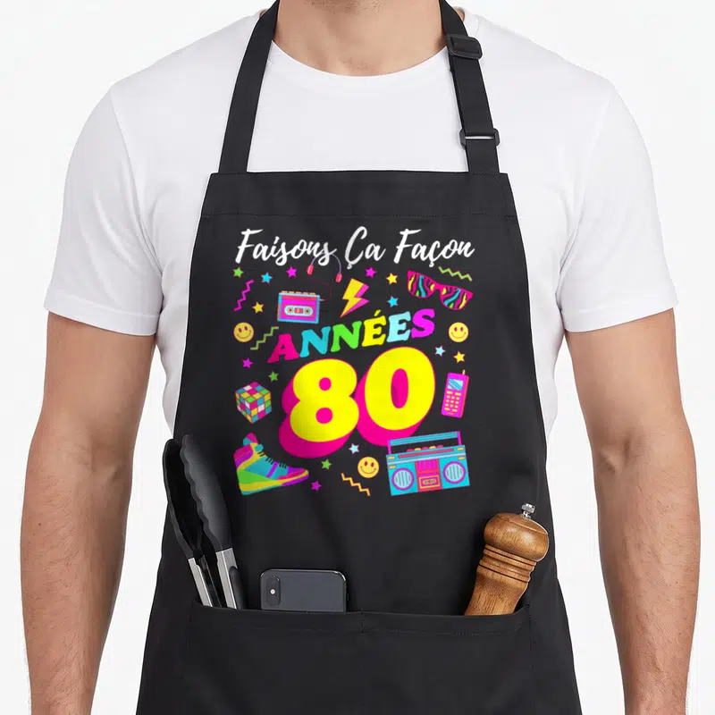 Tablier de cuisine noir avec inscription Faisons Ça Façon Années 80 et illustrations rétro colorées.