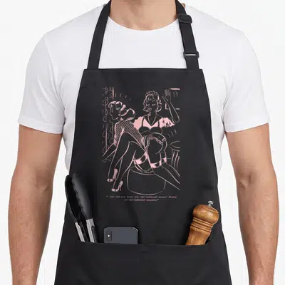 Tablier de cuisine noir avec illustration rose d'une scène pinup vintage et texte en anglais humoristique en bas du motif.