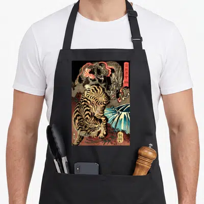 Tablier de cuisine noir avec illustration rétro d'un dragon affrontant un tigre géant sur fond de gravure japonaise.