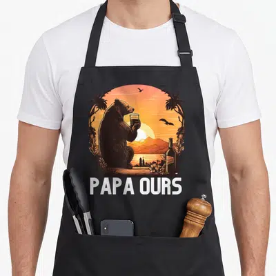 Tablier de cuisine noir avec illustration d'un ours buvant une bière au coucher de soleil et texte Papa Ours en bas.
