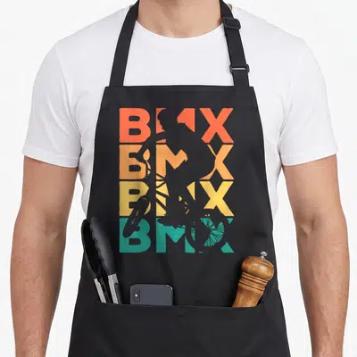 Tablier de cuisine noir avec silhouette bicrosseur et texte BMX multicolore style rétro