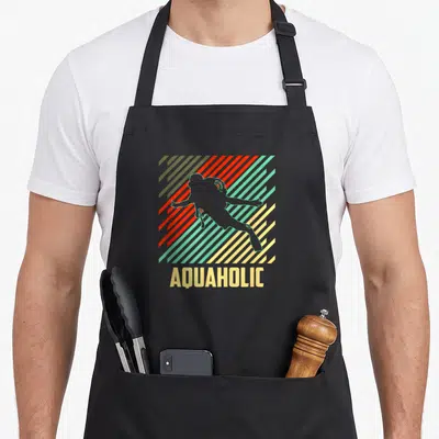 Tablier de cuisine noir avec silhouette de plongeur et texte aquaholic sur fond de rayures diagonales multicolores.