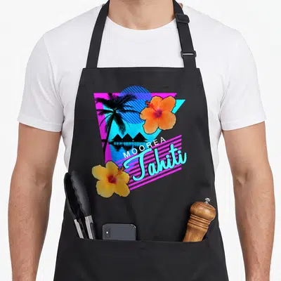 Tablier de cuisine noir avec motif tropical rétro années 80 affichant Moorea Tahiti et des fleurs d'hibiscus colorées.