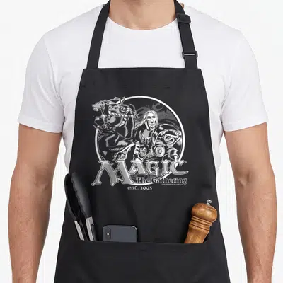 Tablier de cuisine noir avec une illustration blanche circulaire représentant un personnage et un cheval au-dessus du texte Magic The Rassemblement est 1993.