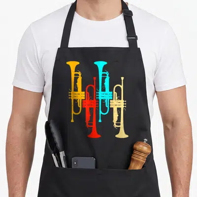 Tablier de cuisine noir avec quatre trompettes stylisées orange, rouge, bleue et jaune sur fond uni.