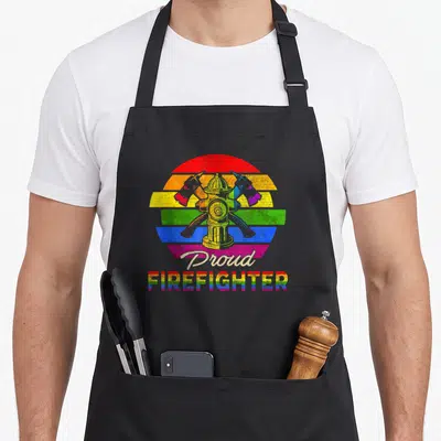 Tablier de cuisine noir avec illustration drapeau arc-en-ciel vintage et texte Proud FIREFIGHTER en bas.