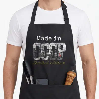 Tablier de cuisine noir avec inscription « Made in CCCP Limited edition » et motif industriel gris et rouge.