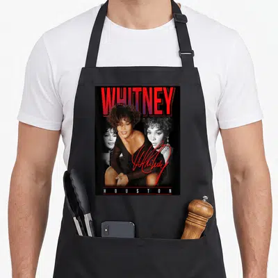 Tablier de cuisine noir avec collage photo rétro de Whitney Houston et son nom en rouge.
