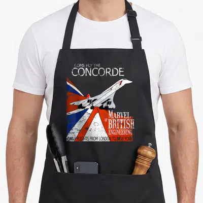 Tablier de cuisine noir avec illustration rétro du Concorde et texte blanc sur fond aux couleurs du drapeau britannique.