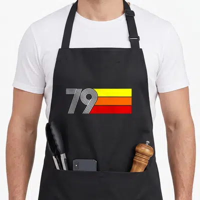 Tablier de cuisine noir avec linscription 79 stylisée en blanc surbandes horizontales jaune orange et rouge vif.
