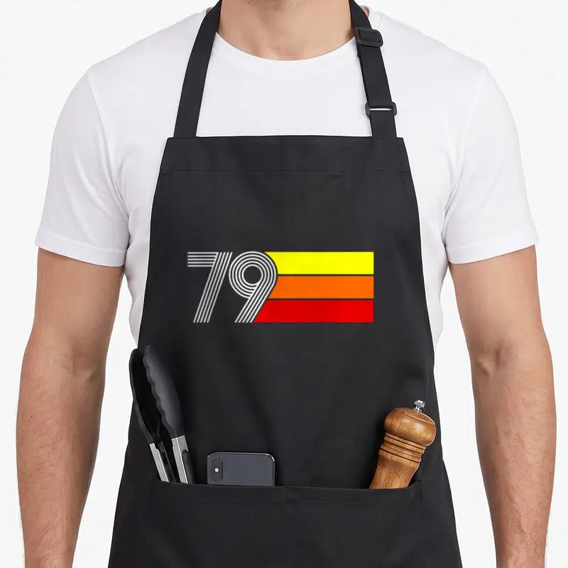 Tablier de cuisine noir avec l'inscription 79 stylisée en blanc surbandes horizontales jaune orange et rouge vif.