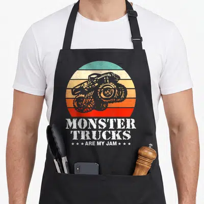 Tablier de cuisine noir avec illustration Monster Truck sur fond de soleil couchant rayé retro