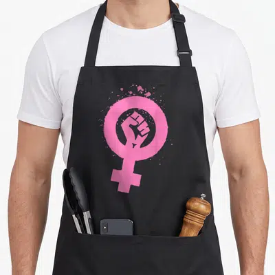 Tablier de cuisine noir avec symbole féminin rose contenant un poing levé et des éclaboussures artistiques.