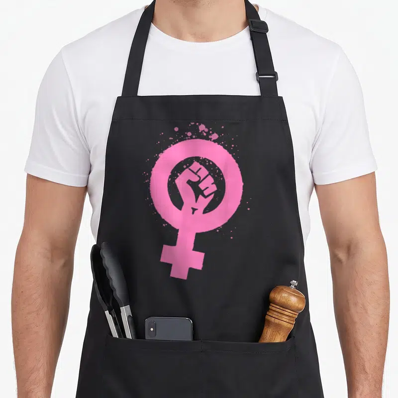 Tablier de cuisine noir avec symbole féminin rose contenant un poing levé et des éclaboussures artistiques.