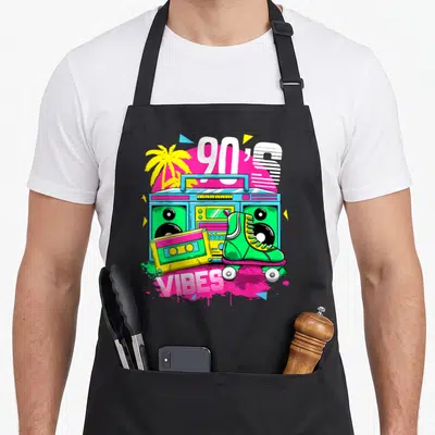 Tablier de cuisine noir avec une illustration colorée d'une boombox, des patins à roulettes et le texte 90's Ambiance en style rétro.