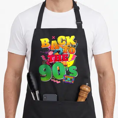 Tablier de cuisine noir avec inscription Back to the 90's et illustration de cassette audio colorée.