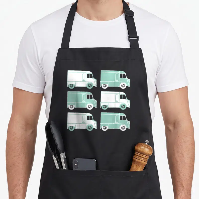 Tablier de cuisine noir avec six illustrations de Citroën Type H Van alternant blanc et vert menthe sur fond gris uni.