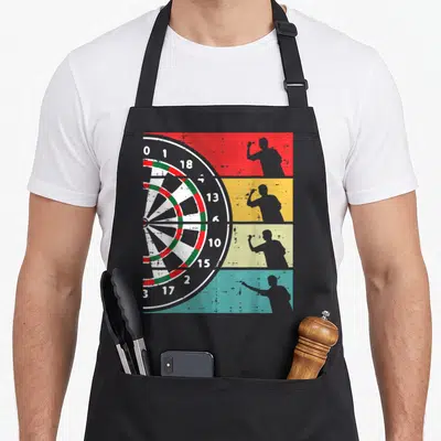 Tablier de cuisine noir avec illustration d'une cible de fléchettes et quatre silhouettes de joueurs sur bandes de couleurs rétro.
