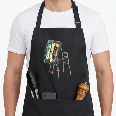 Tablier de cuisine noir avec illustration d'une cassette mix tape vintage utilisant une aide à la marche.