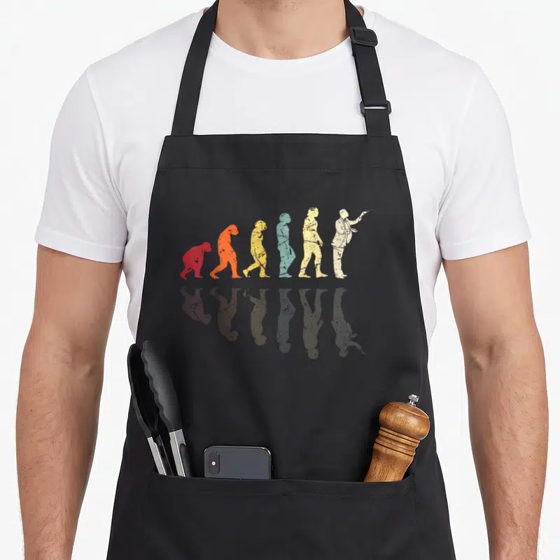 Tablier de cuisine noir avec illustration évolutive colorée se terminant par un chef d'orchestre en costume blanc.