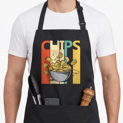 Tablier de cuisine noir avec inscription Chips en lettres multicolores et illustration d'un bol de croustillantes dorées.