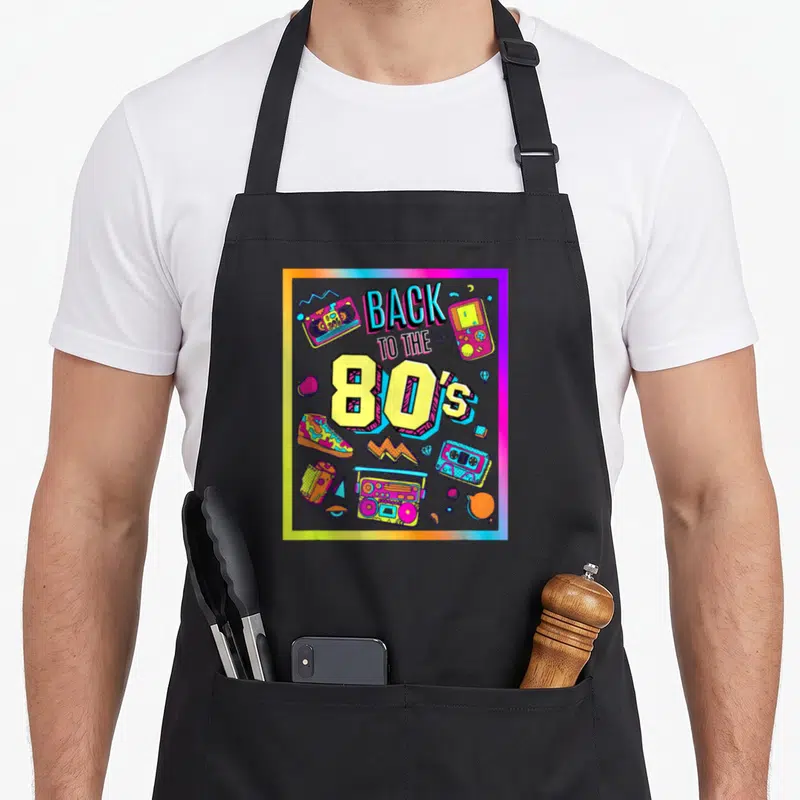 Tablier de cuisine noir avec illustration colorée Back to the 80's et objets rétro.