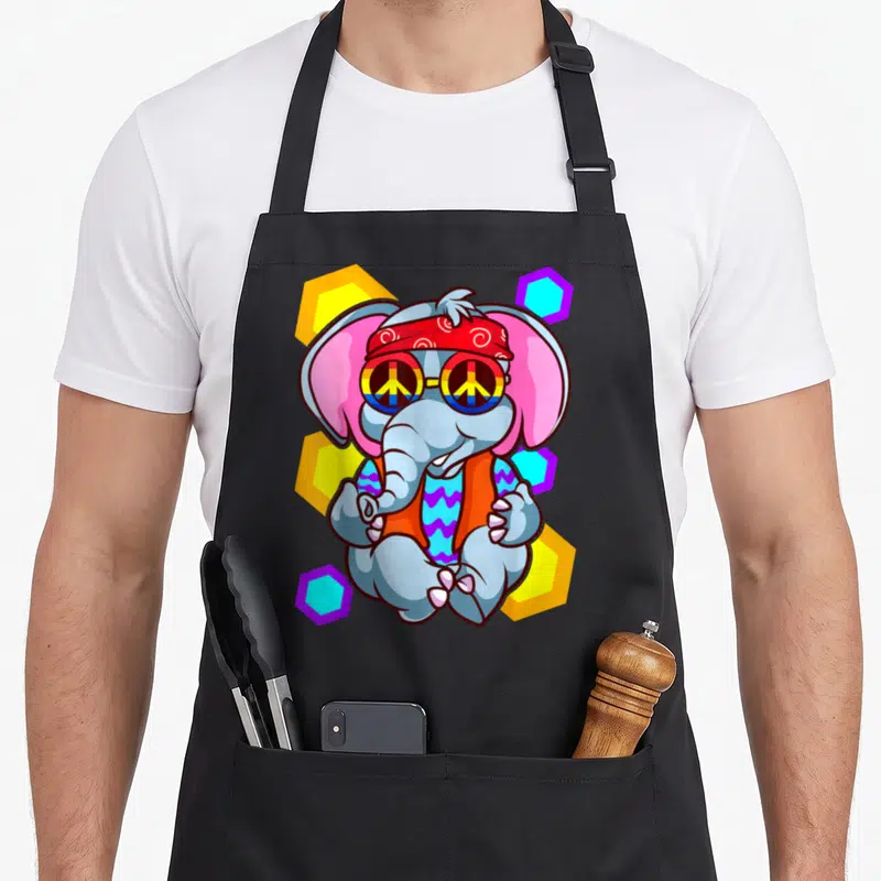 Tablier de cuisine noir avec un éléphant hippie aux lunettes de paix et un bandana rouge sur fond géométrique coloré.