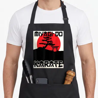 Tablier de cuisine noir avec illustration Miyagi-Do Karate, soleil rouge, bonsaï et porte torii en style rétro.