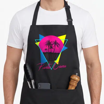 Tablier de cuisine noir avec illustration rétro soleil rose palmiers et texte Punta Cana en rose.