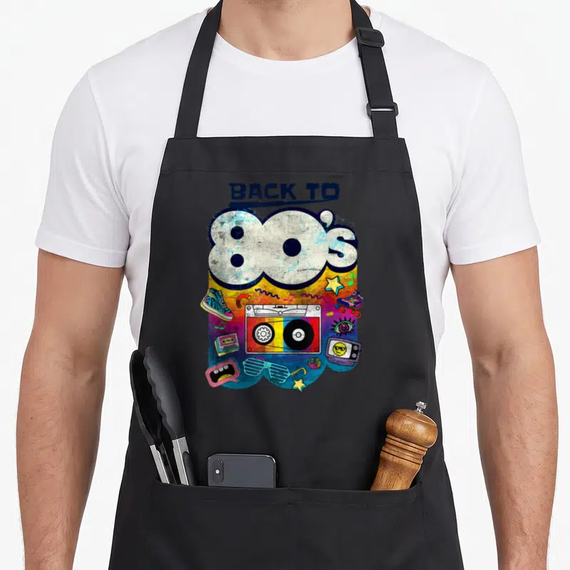 Tablier de cuisine noir avec illustration colorée Back to 80s, boombox, sneakers et étoiles sur fond dégradé.