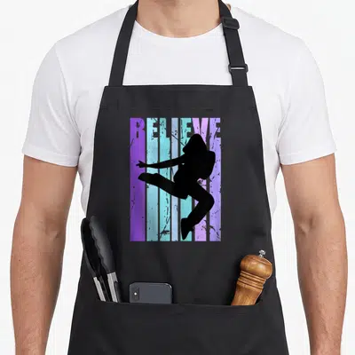 Tablier de cuisine noir avec silhouette de danseuse street dance et texte Believe en bandes violettes et bleues délavées.