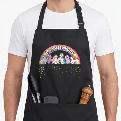 Tablier de cuisine noir avec logo My Little Pony arc-en-ciel rétro et personnages colorés suspendus.