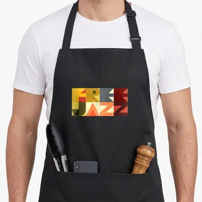 Tablier de cuisine noir avec une illustration rectangulaire Free Jazz en lettres géométriques orange, jaune et gris foncé.