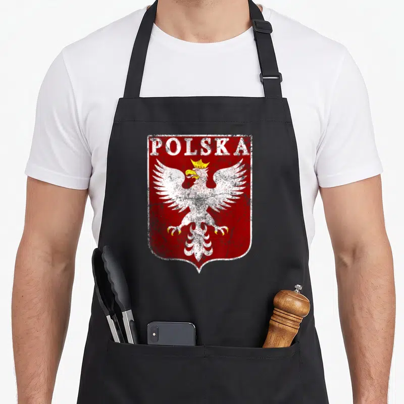 Tablier de cuisine noir avec un aigle blanc couronné et le mot POLSKA sur fond rouge texturé.