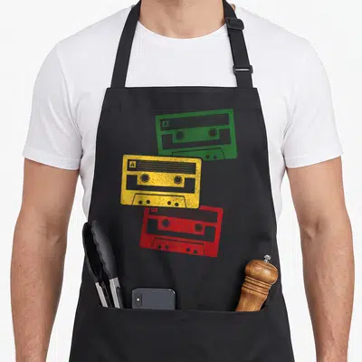 Tablier de cuisine noir avec trois cassettes audio jaunes, vertes et rouges style rétro.