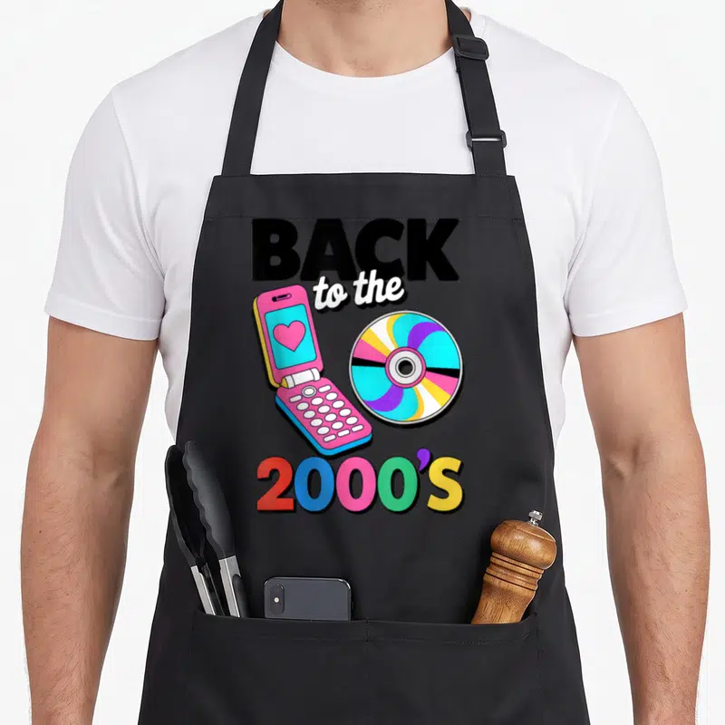 Tablier de cuisine noir avec un téléphone portable rose à clapet et un disque compact multicolore au design des années 2000.