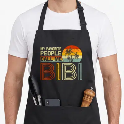 Tablier de cuisine noir avec motif rétro My Favorite Gens Call Me Bibi et soleil aux palmiers.