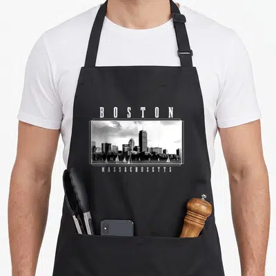 Tablier de cuisine noir avec illustration du skyline de Boston et texte Massachusetts en blanc.