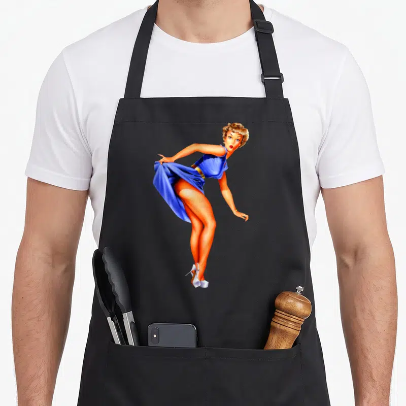 Tablier de cuisine noir avec illustration d'une Pin-up Girl en robe bleue et talons blancs style années 1940.