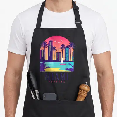 Tablier de cuisine noir avec illustration colorée du skyline de Miami Florida au coucher du soleil