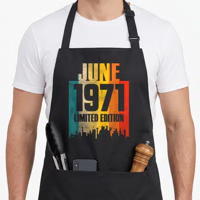 Tablier de cuisine noir avec motif typographique coloré Juin 1971 Limited Edition et skyline en bas.