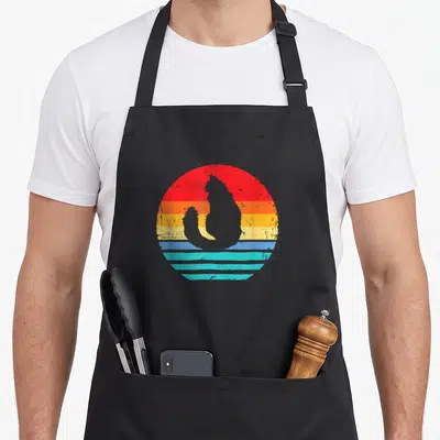 Tablier de cuisine noir avec silhouette Maine Coon sur fond de sunset rétro multicolore