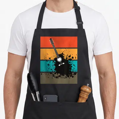 Tablier de cuisine noir avec illustration d'une guitare noire sur bandes colorées orange turquoise et ocre style rétro.