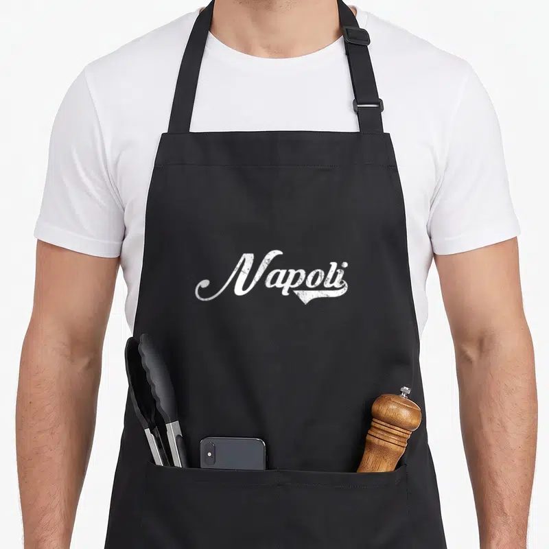 Tablier de cuisine noir avec l'inscription Napoli en lettres blanches style vintage et calligraphie old school.