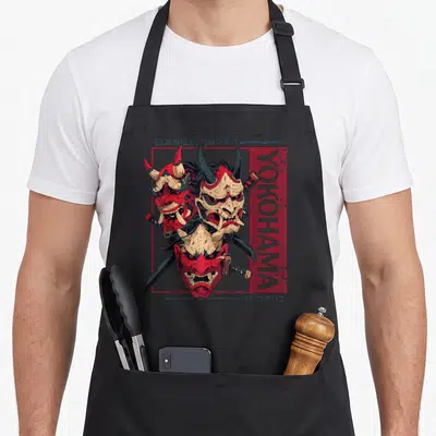 Tablier de cuisine noir avec trois masques démons rouges et l'inscription Yokohama en vertical.