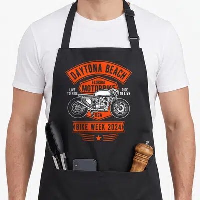 Tablier de cuisine noir avec illustration rétro moto Daytona Beach Bike Week 2024 en orange et blanc.