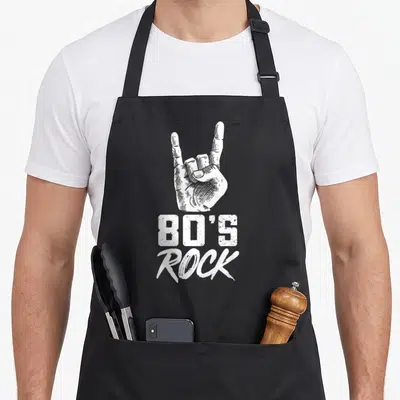 Tablier de cuisine noir avec une main blanche formant le signe du rock et le texte 80's Rock en dessous.